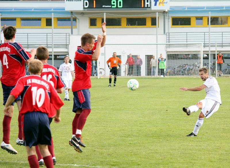 Prostějov (bílé dresy) v sobotním utkání s Mikulovicemi. Rozhodující střela zápasu – Petr Papoušek (vpravo) v nastavení posílá míč přes zeď Mikulovic a jeho střela se odráží od spojnice za brankovou čáru – 2:1.