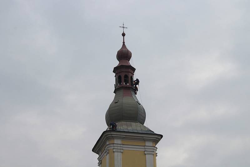 Skupina lezců natírá báň kostela svatého Bartoloměje v Zábřehu.