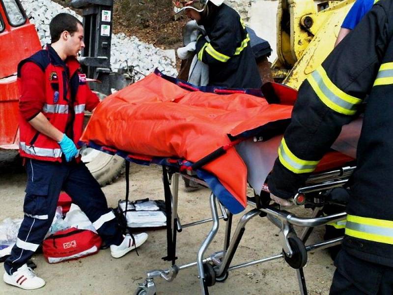 Záchranáři se snaži pomoci muži, kterého v Žulové zavalila radlice