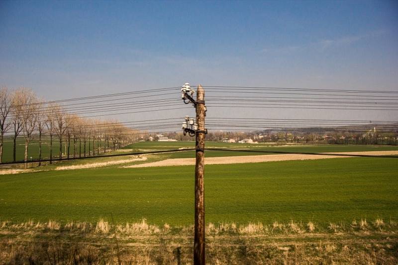 Pohled na vesnici Charbielin. Že je trať na území Polska ve špatném stavu, naznačuje nejen nízká rychlost vlaku, ale i hlasité klepání kol o kolejnice. K opravě trati se polská strana nemá. 