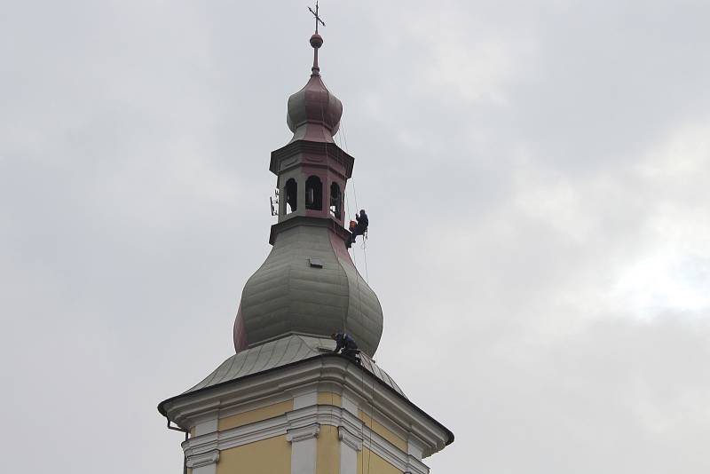 Skupina lezců natírá báň kostela svatého Bartoloměje v Zábřehu.