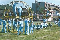 4. SVAZARMOVCI. Vystoupení svazarmovců na okresní spartakiádě v roce 1980. V pozadí fotografie se nachází hotel Sport a areál šumperského zimního stadionu.