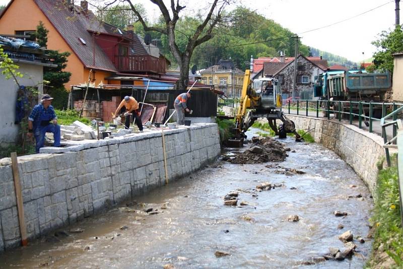 Pracovníci stavební firmy opravují koryto potoka v Javorníku poškozené povodní.
