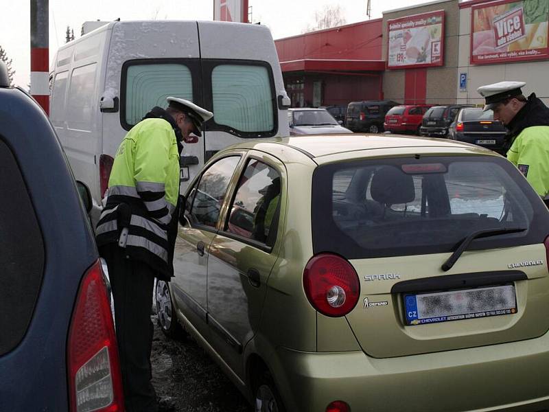 Policejní snímky aut zaparkovaných před jedním šumperským supermarketem