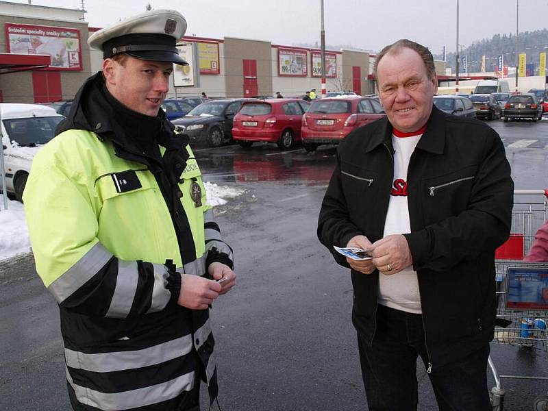 Policejní snímky aut zaparkovaných před jedním šumperským supermarketem