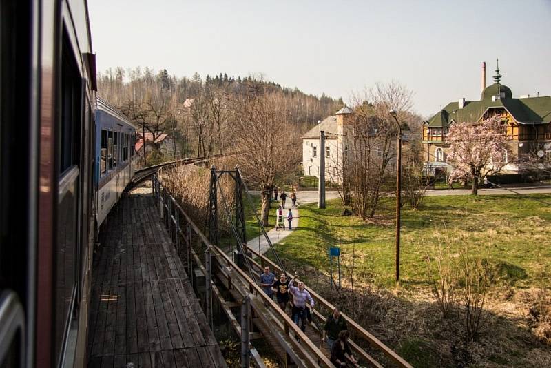 Železnice obtáčí celé město. Pro místní je vlak atrakce, podél trati mu mávají skupinky výletníků. 