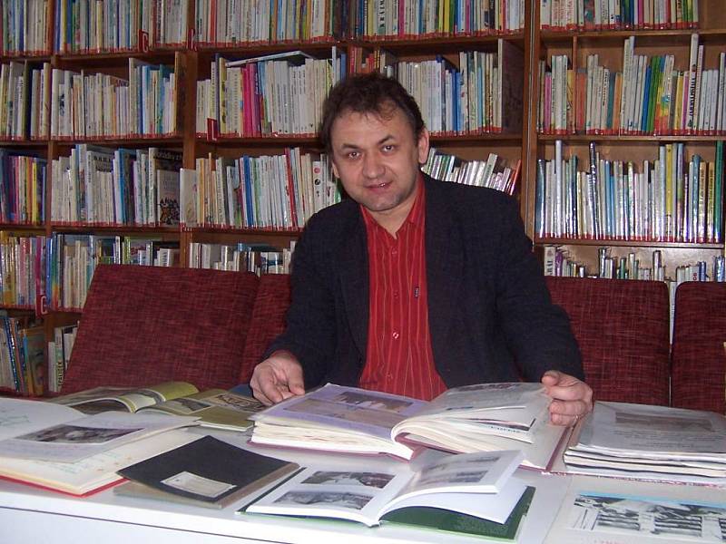 Ředitel Miloš Richter si prohlíží staré kroniky přibližující historii knihovny.