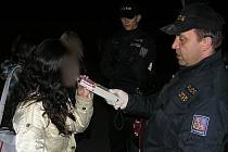 Policista kontroluje dívku, zda požila alkohol