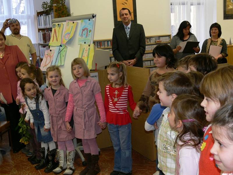Starosta Šumperku Zdeněk Brož předává v knihovně dětem jejich první vysvědčení.