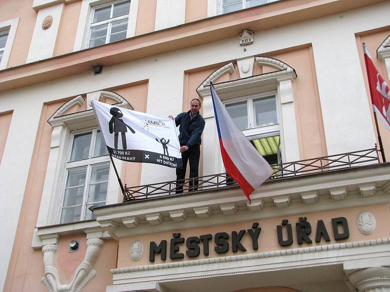 Místostarosta Mohelnice Pavel Kuba upravuje vlajku, která symbolizuje boj obcí za nové přerozdělení daní