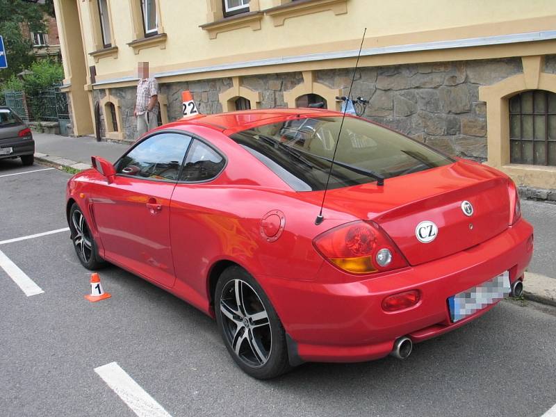 Červené auto v Jeremenkově ulici během nehody opilého cyklisty. 