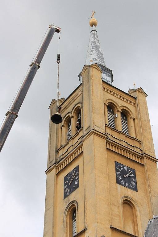 Zdvihání a instalace nového zvonu do věže kostela ve Vidnavě a snášení jeho starého předchůdce.
