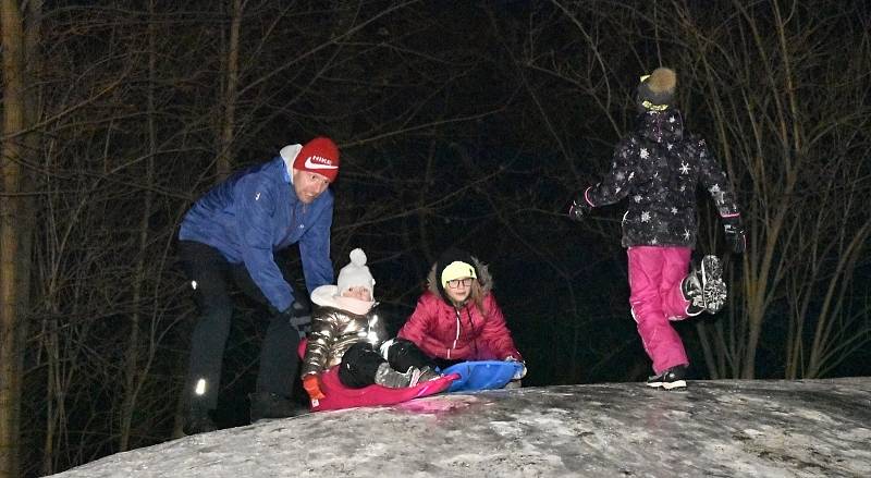 Nasvícený "pahorek" u říčky Hloučely láká malé i velké bobisty a sáňkaře.