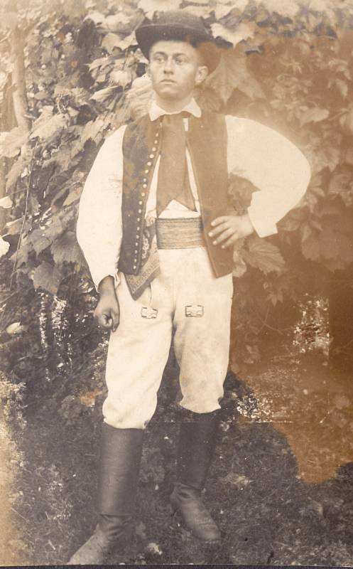 Ukázka mužského němčického kroje – vysoké špičaté boty na podpatcích, žluté přiléhající kožené kalhoty, široké pásy, soukenná kordula, na krku černý hedvábný šátek, košile se širokými rukávy a vyšívaným límcem, kulatý klobouk.