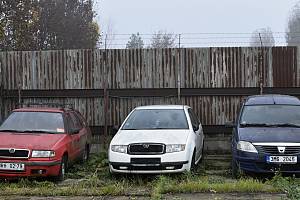 Osobní automobily různých značek čekají na dražbu v areálu kovošrotu za hlavním nádražím.