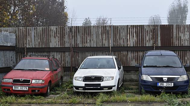 Osobní automobily různých značek čekají na dražbu v areálu kovošrotu za hlavním nádražím.