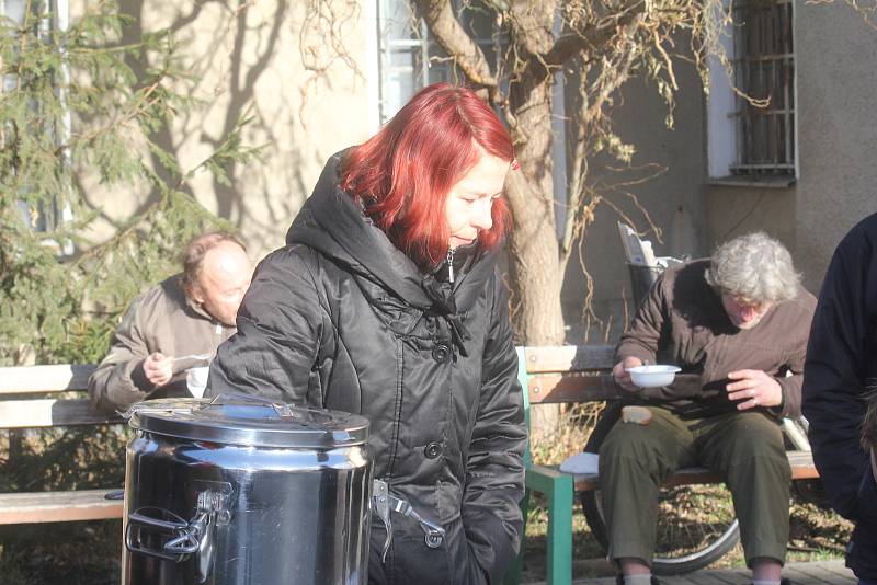 Dobrovolníci rozdávají lidem bez domova polévku u místního nádraží v Prostějově