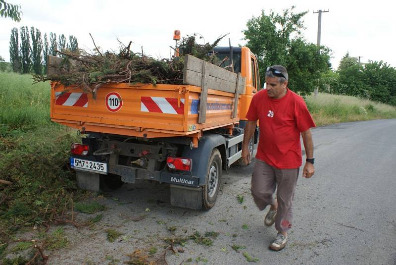 Úklid odpadu pohozeného v okolí kontejnerů na místní cestě od plumlovského kostela k přehradě