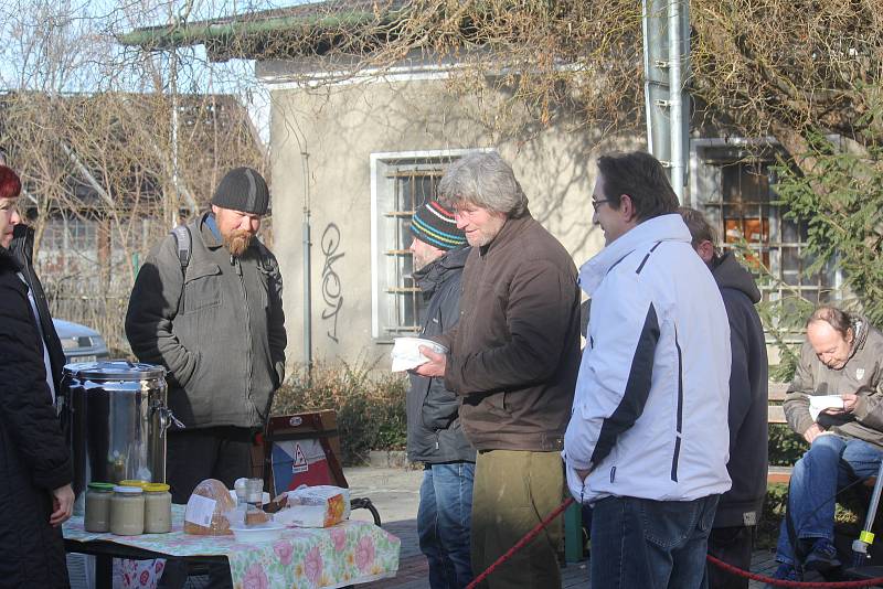 Dobrovolníci rozdávají lidem bez domova polévku u místního nádraží v Prostějově