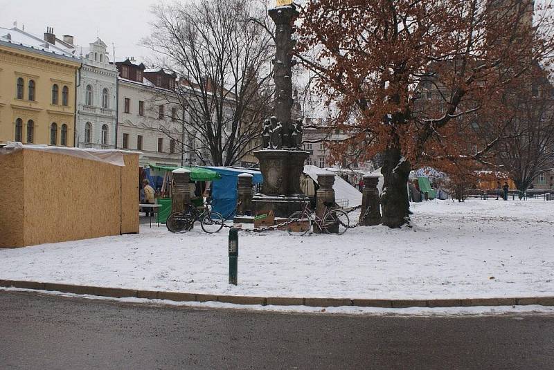 Desítku stylových dřevěných stánků na náměstí při vánočních trzích doprovázejí další jejich ne moc vkusní igelitoví kolegové 