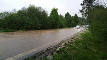 Voda z rozvodněného potoka zaplavila v neděli odpoledne při vydatném dešti silnici mezi Českým Krumlovem a Frymburkem poblíž obce Světlík.