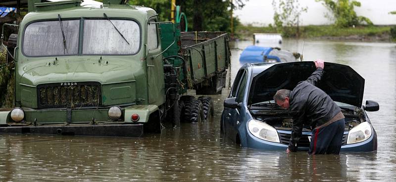 Majitel přišel osvobodit své auto ze zajetí vody a z místa, kam ho voda zanesla.