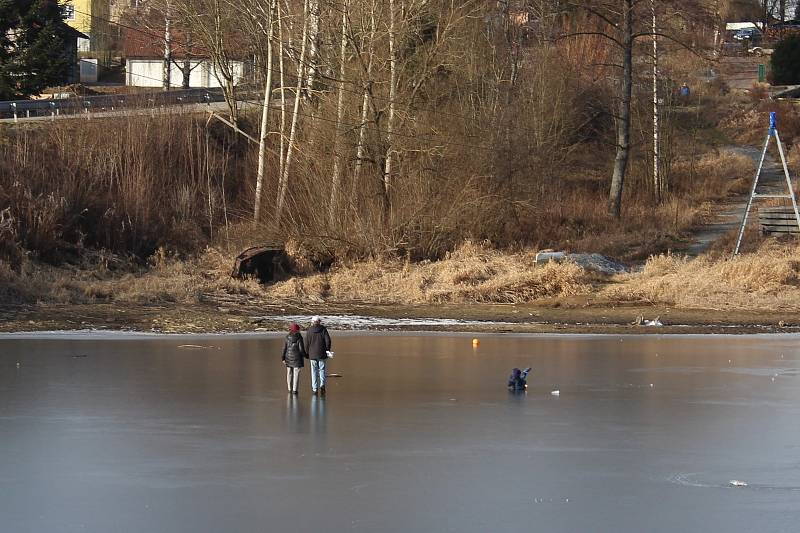 Rodina s malým dítětem se ve Frymburku na led v pátek vydala i přesto, že led je ještě slabý. Naštěstí se neprobořili.