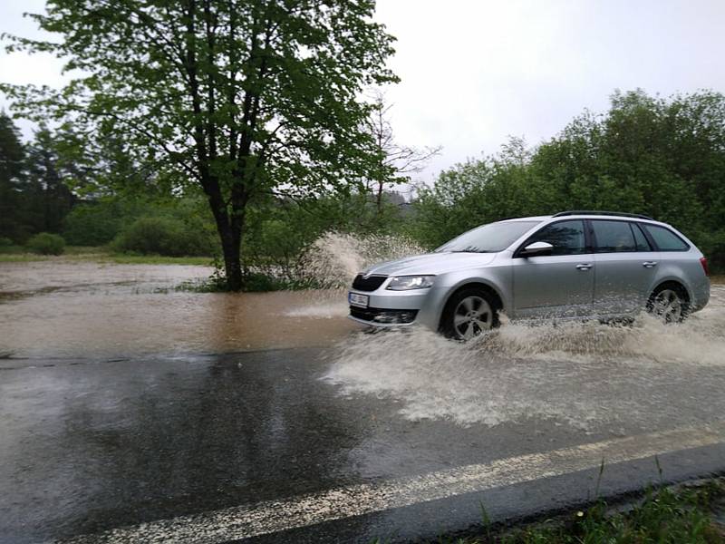 Voda z rozvodněného potoka zaplavila v neděli odpoledne při vydatném dešti silnici mezi Českým Krumlovem a Frymburkem poblíž obce Světlík.