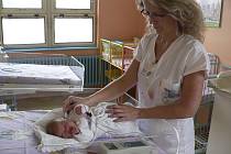 Sestřička v českokrumlovské nemocnici vyšetřuje sluch novorozence.