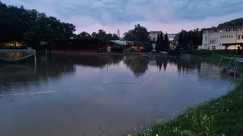 Povodeň v Českém Krumlově na Polečnici v okolí Chvalšinské ulice. Říčka, která v noci dosáhla 3. SPA, zaplavila tenisové kurty a penzion, okolí gymnázia vč. nového fotbalového hřiště, cykloprodejnu nebo bus-stop pod zámkem.