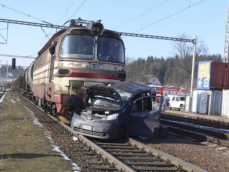 Srážka osobního auta s nákladním vlakem.