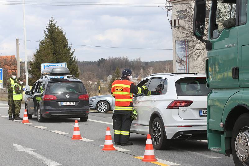 Na hranicích zastavují řidiče policisté. Ve spolupráci s vojáky a hasiči měří cestujícím teplotu a informují je o tom, co mají po příjezdu domů dělat.