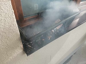 Následky požáru, který se rozšířil z nedopalku cigarety v květináči na balkoně bytovky.