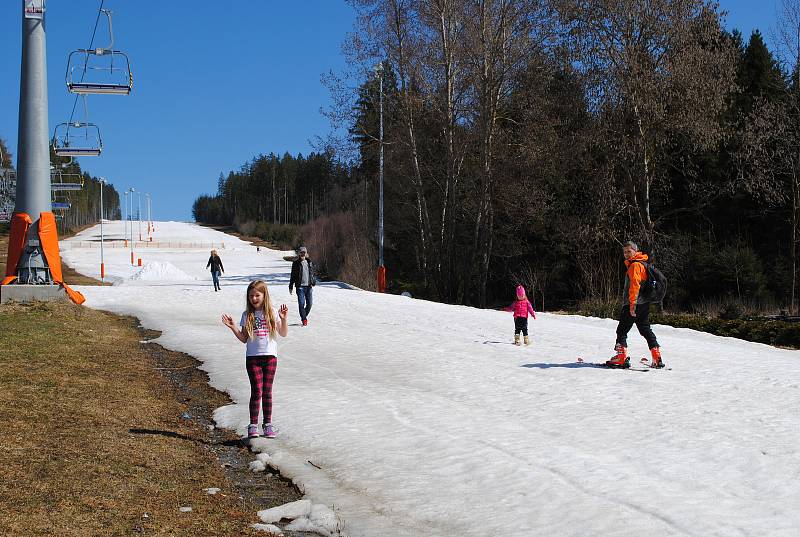 Trička s krátkým rukávem, koloběžky, kola, zimní bundy, parta dětí na bobech, tatínek s dcerkou na lyžích... Zimní sezóna na Lipně skončila před týdnem, ale půl metru sněhu na sjezdovce ladem neleží.