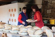 Členové spolku přátel Velešína vytahují z pece čerstvě upečený chléb.