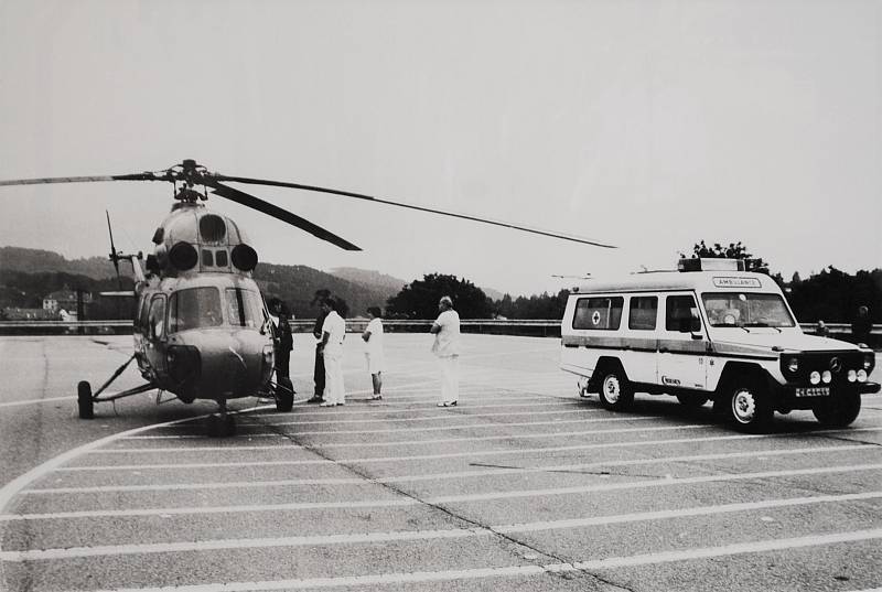 Český Krumlov v roce 1992. Na asfaltové ploše u hřbitova přistávají vrtulníky záchranné služby.