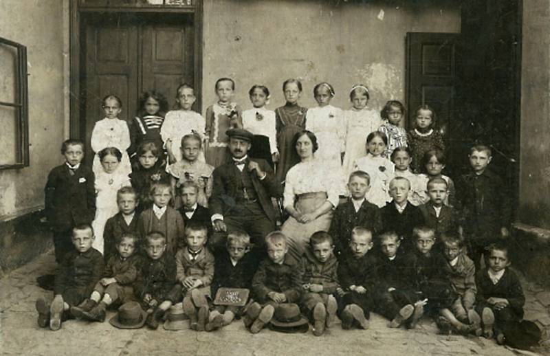 První škola v Loučce byla v jedné místnosti, v rodinném domě Šebestových, zde se učily všechny děti dohromady. Fotografie pochází pravděpodobně z roku 1914.