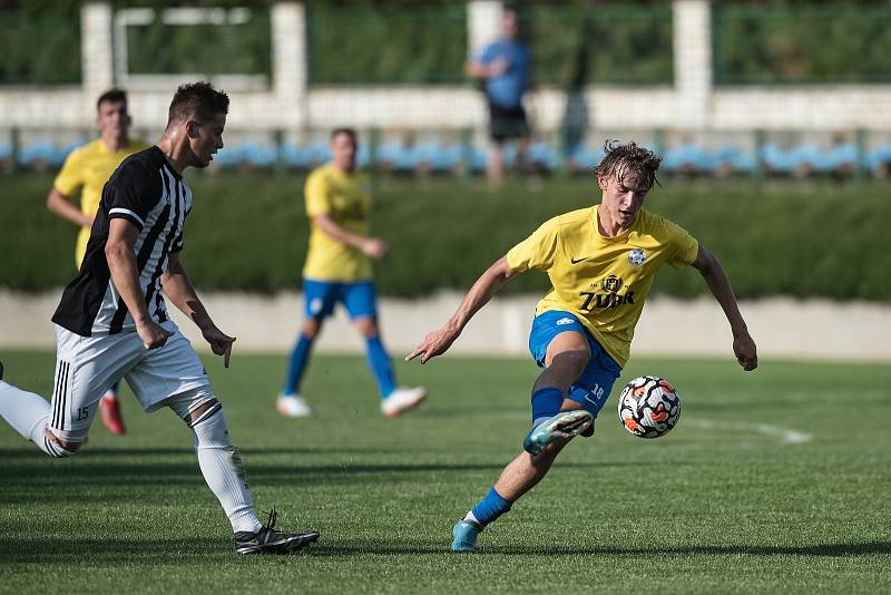 Fotbalisté FK Kozlovice (ve žlutém) proti SFK ELKO Holešov. Dominik Skopal (u míče)