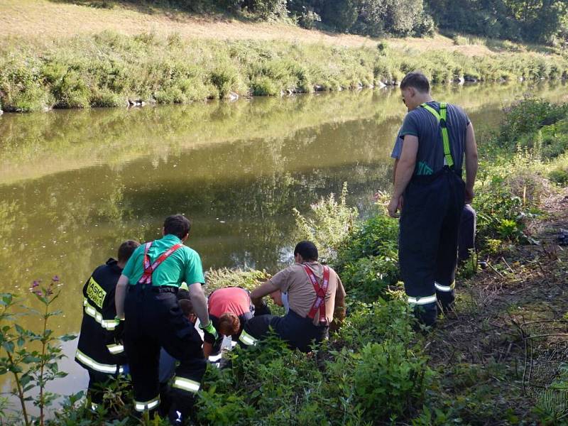 Hasiči a záchranáři pomáhají muži, který se zranil při lovu sumce u Oseku nad Bečvou