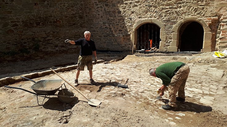 Členové archeologického týmu Jan Novotný a Josef Dokoupil preparují povrch renesanční dlažby na Helfštýně