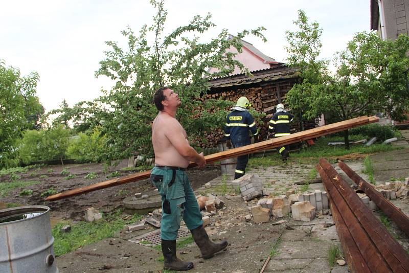 Poničené střechy rodinných domů, vyvrácené stromy a trámy, které se rozletěly jako třísky do okolí. Tak to vypadalo v pátek odpoledne v Uhřičicích na Kojetínsku, kterými se prohnala silná vichřice