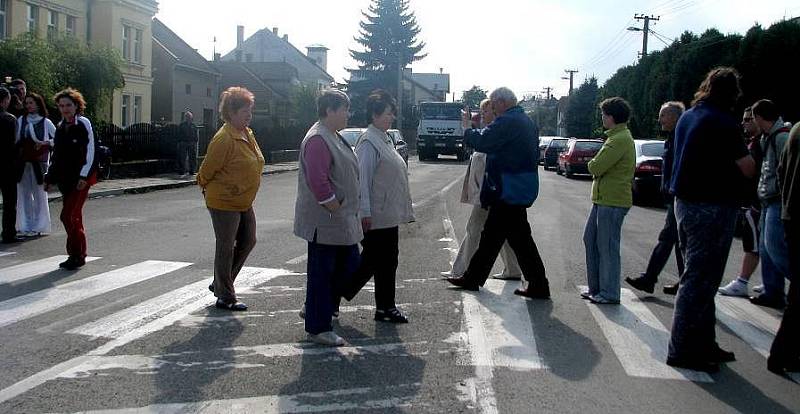 Upozornit na obrovské množství nákladních aut, která projíždějí přes obec Prosenice, se místní lidé pokusili v úterý pomocí blokády. Více než půl hodiny chodili s transparenty přes přechod pro chodce a auta musela čekat nebo se otáčet.