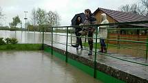Řeka Bečva se v pátek na některých místech rozlila - zaplavila například sportoviště v Ústí na Hranicku.