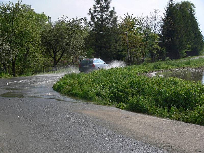 Voda z pole Za Čaputovým dvorem se lila přes silnici a zaplavila okolní zahrádky.