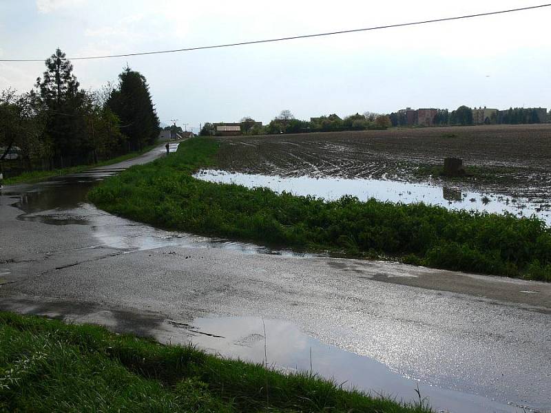 Voda z pole Za Čaputovým dvorem se lila přes silnici a zaplavila okolní zahrádky.