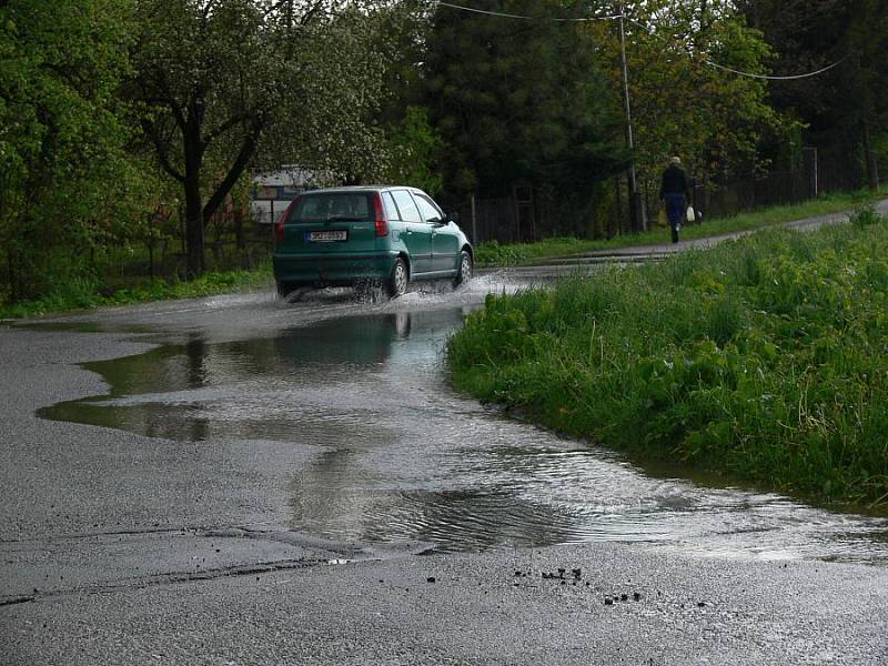 Voda z pole Za Čaputovým dvorem se lila přes silnici a zaplavila okolní zahrádky.