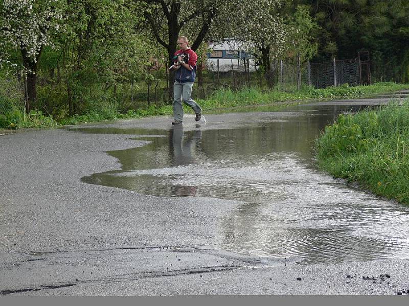 Voda z pole Za Čaputovým dvorem se lila přes silnici a zaplavila okolní zahrádky.