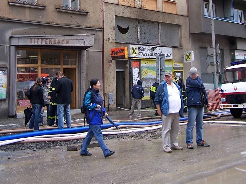 Kusy dlažby a betonu zasáhly po explozi také dva protější domy. Poničena byla nejen okna, ale také fasády obou objektů.