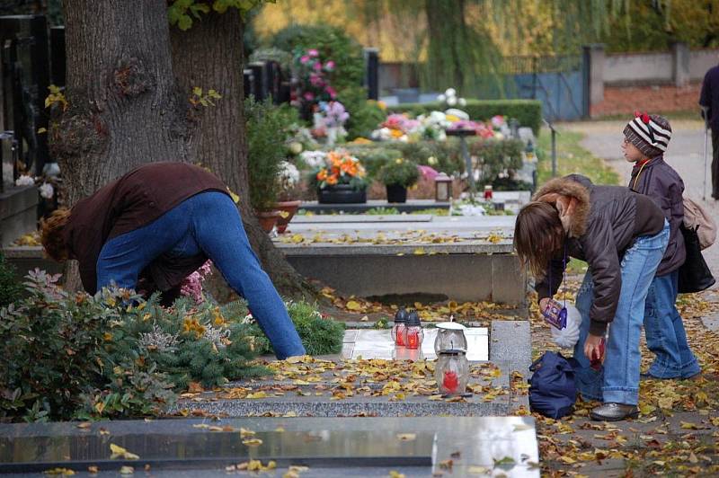 Záplava květin a věnců, hořící svíce u vsypové loučky, tak to vypadá v těchto dnech na přerovském hřbitově.