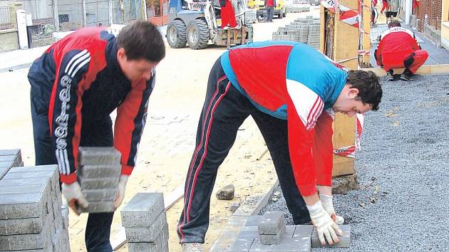 Stavebníci v Nerudově ulici v Přerově upravují povrch vozovky a dláždí chodníky